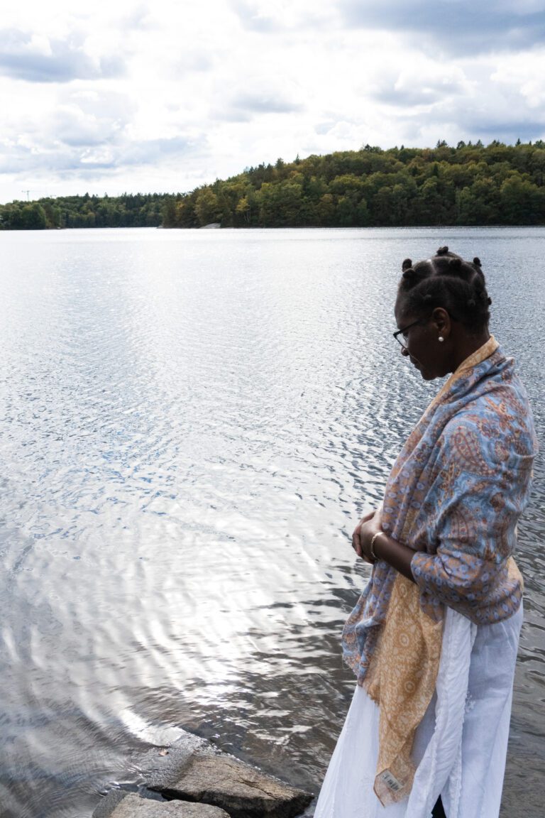 Jacqueline Vanderpuye standing by a the water pondering